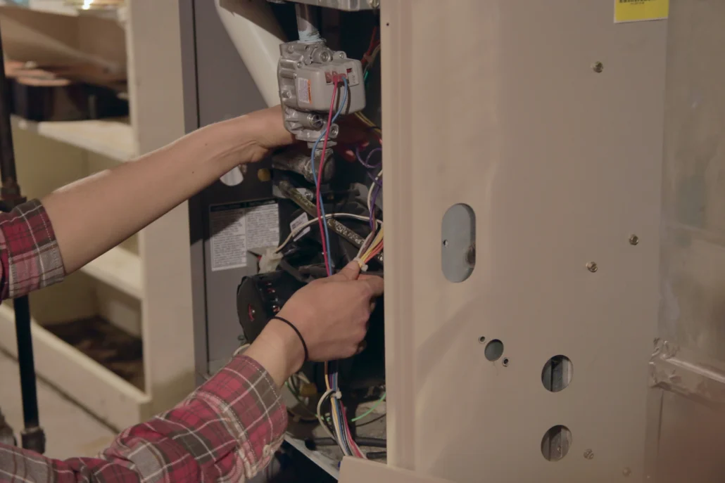 A professional technician repairing a furnace system